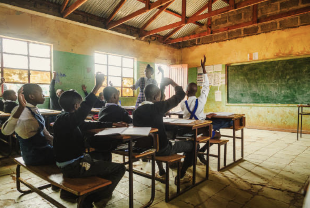 Pupils raising their hands to answer a question in a classroom at The Bevan Morris School